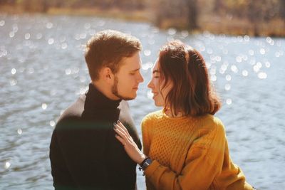 Couple cuddling against lake