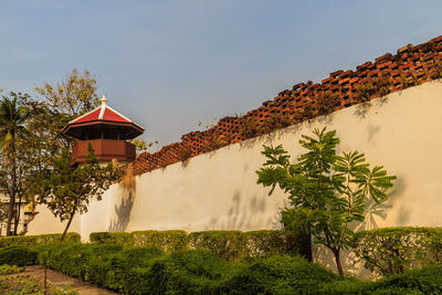 Low angle view of trees and building against sky