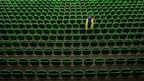 High angle view of woman standing amidst chairs