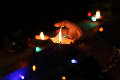 Close-up of hand holding lit diya