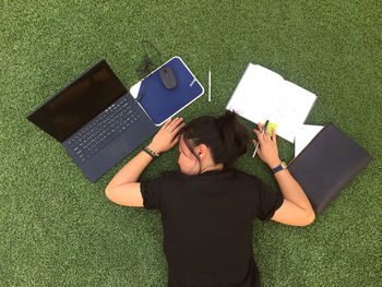 High angle view of woman lying on book