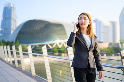 Young woman using mobile phone in city