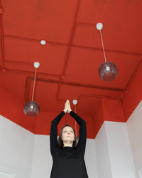 Low angle view of woman standing against wall