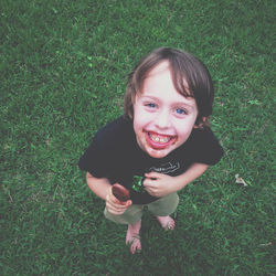 Portrait of happy girl standing on grassy field