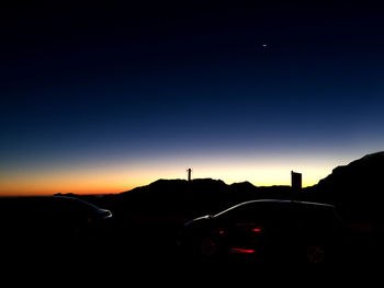 Silhouette of road against sky at sunset