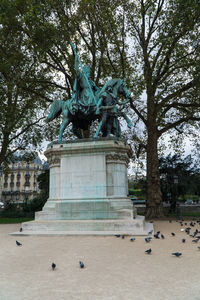 Statue in city against sky