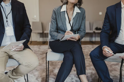 Midsection of male and female colleagues at corporate office