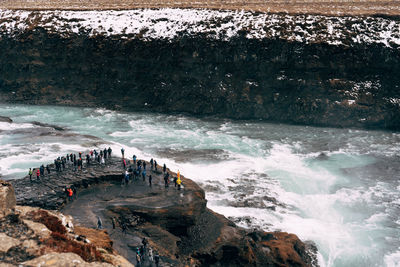 Group of people on rocks by sea