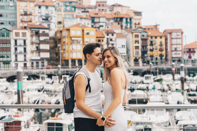 Couple embracing while standing against cityscape