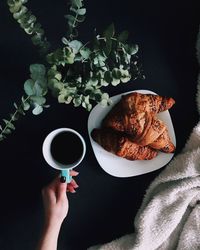 Directly above shot of woman holding coffee cup on table