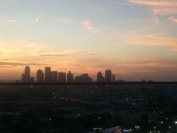 Buildings in city against sky during sunset