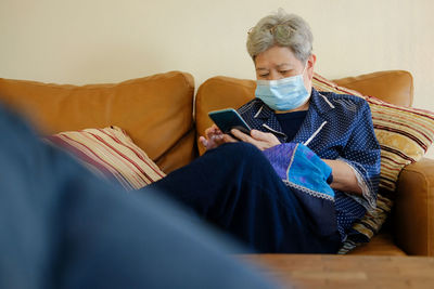 Asian elder senior woman elderly female wearing mask using mobile smart phone. retirement lifestyle