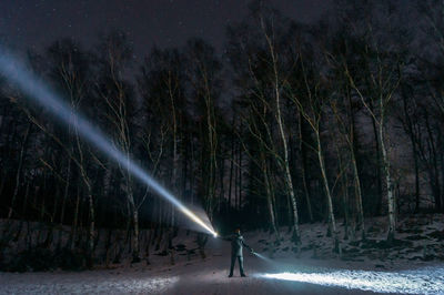 Man amidst trees in forest during winter