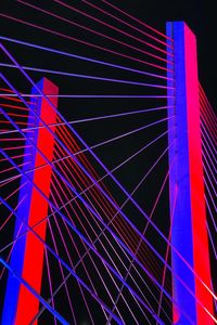 Low angle view of illuminated ferris wheel against blue sky