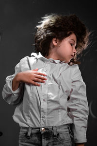 Man looking away while standing against black background