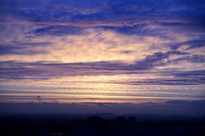 Scenic view of silhouette buildings against sky at sunset