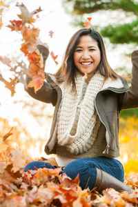 Portrait of smiling young woman with autumn leaves