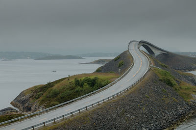 High angle view of winding road over sea against sky