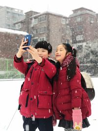 Portrait of woman photographing with camera in winter