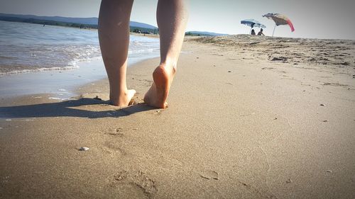 Low section of woman walking on beach