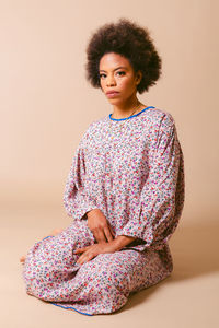 Portrait of young woman standing against white background