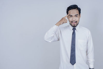 Young man standing against white background