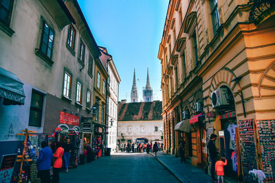 People walking on street amidst buildings in city