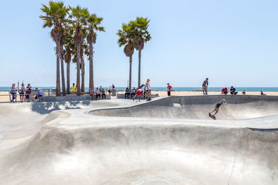 People on beach against clear sky