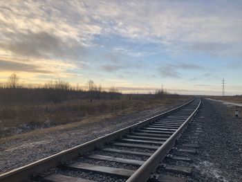 Railroad tracks against sky during sunset