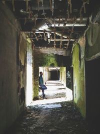 Rear view of woman walking in abandoned building