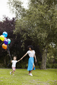 Mother with son walking with bunch of balloons