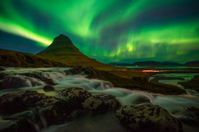 Beautiful aurora dancing over kirkjufell mountain in iceland, image noise due high iso 