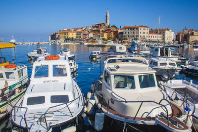 High angle view of sailboats moored on sea against buildings in city