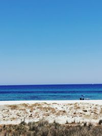 Scenic view of sea against clear blue sky