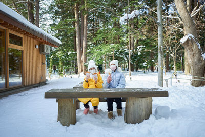 Woman sitting on snow covered field