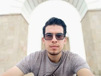 Portrait of young man wearing sunglasses in city