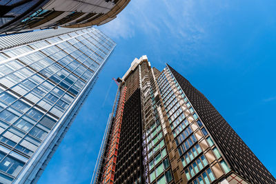 Low angle view of modern skyscraper against blue sky