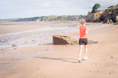 Full length of woman jogging at beach