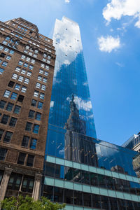 Low angle view of modern buildings against blue sky