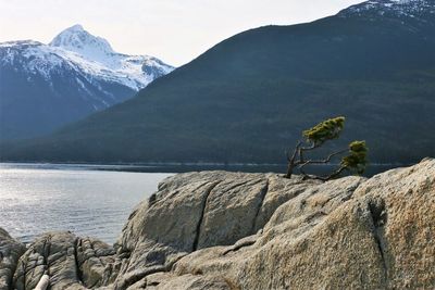 Scenic view of sea and mountains against sky