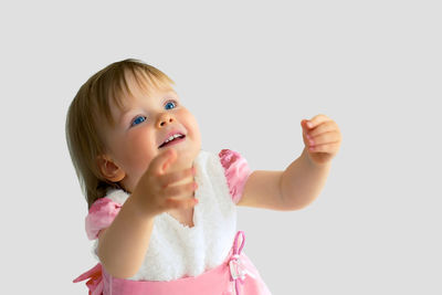 Portrait of cute boy looking away against white background