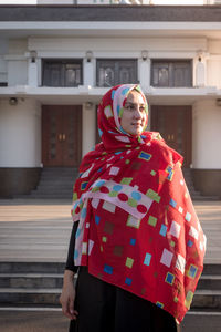 Full length of woman standing against building in city