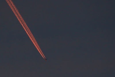 Airplane flying against sky at night