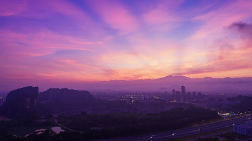 Scenic view of city against sky during sunset