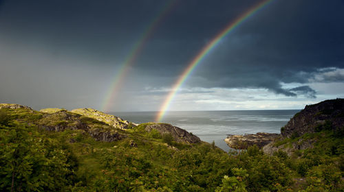 Scenic view of rainbow over sea against sky