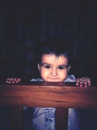 Portrait of cute smiling boy in darkroom