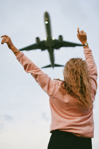 Low angle view of woman standing against sky