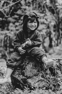 Portrait of mother and girl sitting on land