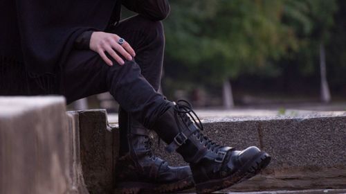 Low section of man sitting on steps in city