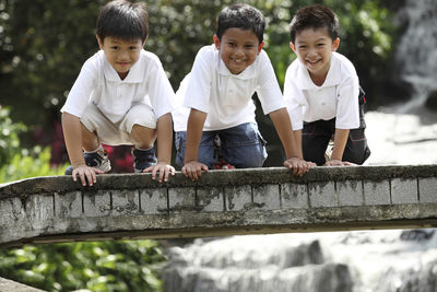 Happy boys on footbridge over stream